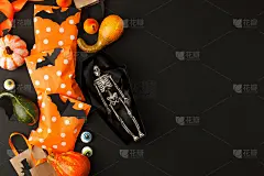 万圣节概念快乐。装饰性的男人骨架在纸手工棺材和传统的糖果袋在黑色背景。万圣节派对贺卡，邀请，横幅，传
