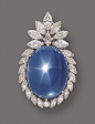 // "Star sapphire and diamond pendant-brooch, circa 1955. The large oval-shaped star sapphire cabochon weighing approximately 145.00 carats, within a frame set with 23 marquise-shaped, 1 round and 1 kite-shaped diamond weighing a total of approximate