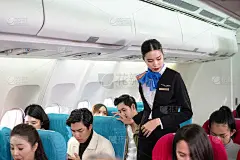 为了安全飞行，穿着制服的空姐要求所有乘客在飞机上都系好安全带。安全系统严密。国际航空公司。假期的长途