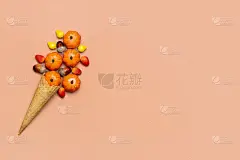 橡子，球果，南瓜，浆果在华夫饼甜筒冰淇淋在橙色的背景上顶部视图秋天的平lay假日卡片