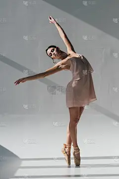 优雅的芭蕾舞演员穿着粉红色的衣服在阳光下跳舞