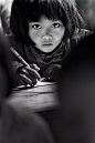 1991年4月，安徽省金寨县桃岭乡三合中心学校的小学生苏明娟在认真听课。此后，这张照片成为共青团“希望工程”的标志。