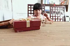 红色的礼品盒放在桌上陪小朋友玩