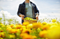 A farmer working in his fields in New York State. A yellow and orange organically grown flower crop. by Mint Images on 500px