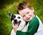 Child lovingly embraces his pet dog by Robert Hainer on 500px