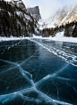 This may contain: an ice floet in the middle of a lake with mountains in the background
