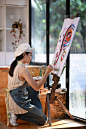 女艺术家在画室里用彩色水在画布上作画的肖像。