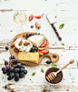 Photograph Cheese appetizer selection or wine snack set. Variety of cheese, grapes, pecan nuts, strawberry and  by Anna Ivanova on 500px