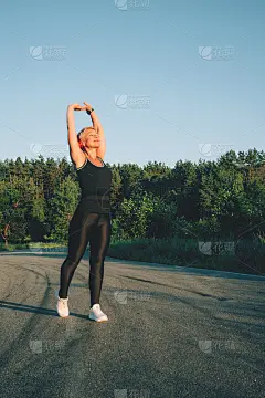 老奶奶在路上跑步前做热身伸展运动。