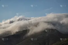 美丽的山景，巨大蓬松的云朵降落到山顶。自然山壁纸。