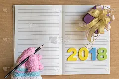 男人阅读记事本与手套和礼盒，数字2018在木板的背景。使用壁纸教育，商业照片为新年快乐形象复制空间。