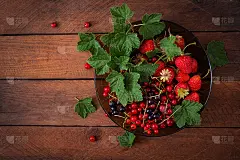 盛有新鲜浆果(草莓和加仑子)的盘子