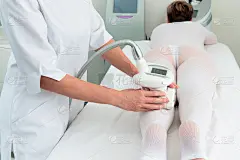 女人在特殊的白色套装得到反脂肪团按摩在水疗沙龙。LPG，以及人体轮廓的临床治疗