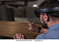 CU young adult Caucasian male using holographic augmented reality glasses in trendy office. Future business concept