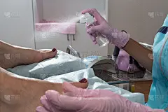 在开始硬件足疗之前，一位戴粉色手套的师傅会进行足部消毒。