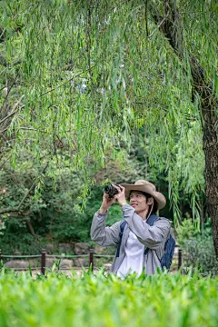 手拿单反相机摄影徒步旅行男生人物摄影图