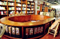 书吧杂货店
环形吧台的设计充分利用了空间，绿色沙发和灯罩，使偏暖的整体设计颜色，小清新了不少。大量格子的使用，让整个空间看上去杂乱中不乏整齐。
(7张)