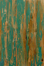 an old wooden wall with peeling paint and chipped paint on the wood, as if it were painted green or yellow