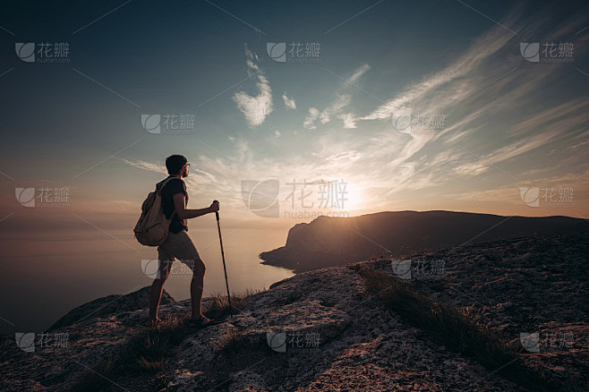 背着沉重背包在日落山徒步旅行的人