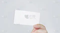 灰色背景上的白色名片。一只手拿着一张名片。经营理念。