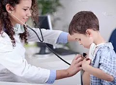 年轻的微笑友好的女医生检查一个小男孩