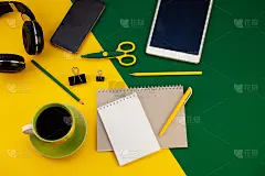 文具在桌面上的视图。黄色和绿色明亮的背景。记事本的笔记与文本的地方。在家里工作。一杯咖啡。布局剪刀，