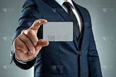 一个穿西装的男人手的特写显示一张名片。模型,布局。网络的概念，商务约会，重要的联系。在灰色背景下拍摄