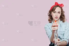 美丽的年轻女子与海报式的化妆和发型与清洁工具在粉红色的背景