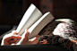 A person reading a book under a blanket