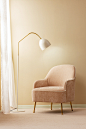 a living room with a chair and a floor lamp