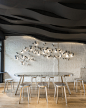 #AC建筑#【咖啡的味觉盛宴】建筑师Alberto Caiola设计上海Fumi咖啡厅。流线雕塑造型的咖色天花板影射咖啡的香气四溢的味觉盛宴。微微倾斜的吧台，为咖啡师绝佳的技艺展示提供舞台。摩卡壶陈列而成的墙面装置，强烈吸引顾客的视线，在大面积镜面的助力之下，室内意趣盎然。来自ArchDaily