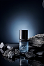Photography of men's skincare products, 1 bottle of gray transparent gradient matte material skincare product, sandwiched in 2 black rocks, product composition centered, stones on the left and right sides, gray tone, simple grayish blue background, soft l