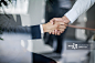 Business handshake in glass reflection in office