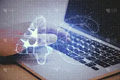 手用笔记本电脑在桌面上绘制抽象的4G网络全息图