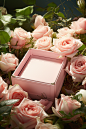 a pink box surrounded by white roses, in the style of nature-inspired imagery, smooth surfaces, sun-kissed palettes, realistic trompe-l'oeil, uhd image, spatial, flat form