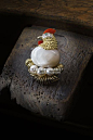 图一为卡地亚动物系列高级珠宝。这一款精致而动人的母鸡胸针创作于1957年，以珍珠贝母、凸纹金、钻石和珊瑚做身体，三颗珍珠做鸡蛋。在电影《摩纳哥王妃》中，也出现了这款胸针的复刻版。@北坤人素材