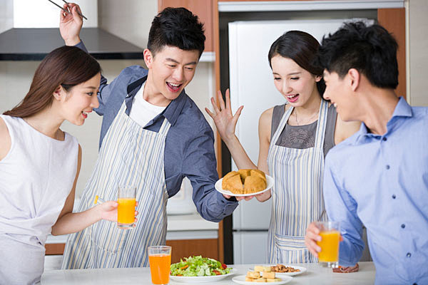 年轻情侣在厨房为朋友做饭