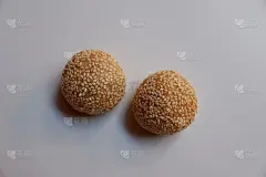 高角度拍摄的煎堆或芝麻球，一种用糯米粉炸成的中式面点，在白色的背景上