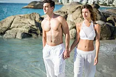 一对手牵着手走在岸上的情侣