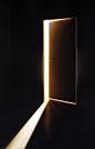 This may contain: an open door in the dark with light coming from it's opening and casting a shadow