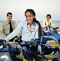 Girl (11-13) sitting on ATV in front of parents, portrait_创意图片