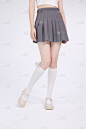 模特穿着灰色短裙和白色长筒袜米色皮鞋的半身照