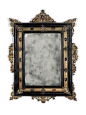 AN ITALIAN HARDSTONE-INSET ENGRAVED BRASS AND EBONISED MIRROR THIRD QUARTER 19TH CENTURY - The rectangular plate within a moulded frame surrounded by pierced scrolling foliage and cherubs - Dim: 26 in. (66 cm.) high; 18 ½ in. (47 cm.) wide.: 