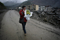 2009年4月1日，四川省绵阳市北川县，一位妇女手捧黄菊哭着走在北川进城的路上。
