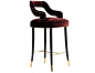 Kelly bar chair dazzles in its smooth mustard velvet and long, elegant legs. The glossy black structure, finished with a delicate touch of gold, complements the polished brass nails that adorn the contours of the graceful backrest.