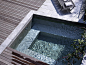  石头、混凝土和木材甲板围成的温泉浴池。