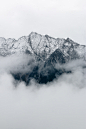 gray mountain covered in fog during daytime