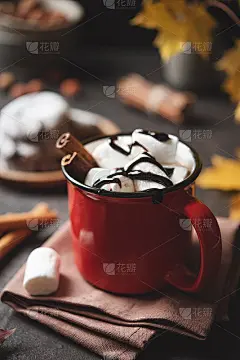 一杯热巧克力、棉花糖和肉桂放在深棕色的桌子上，还有枫叶和饼干。一种暖心的秋季概念。色图像