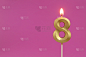 Golden birthday candles on pink background, number