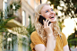 portrait-pretty-cheerful-blond-girl-joyfully-looking-away-while-talking-cellphone-city-street_574295-1022